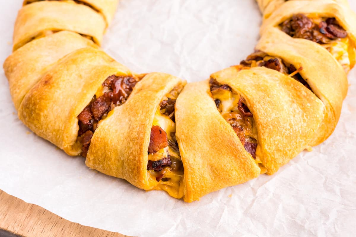 Closeup of part of the Pulled Pork Crescent Ring on parchment lined baking sheet