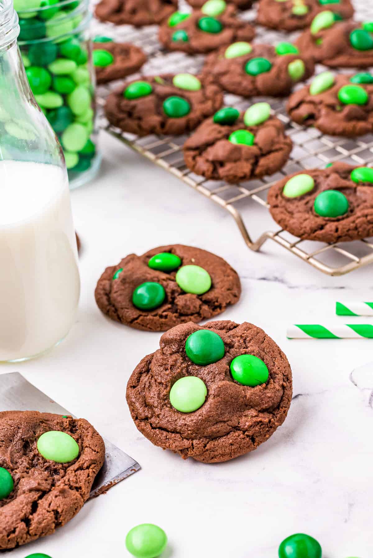 Cookies set on a table beside a glass of milk.