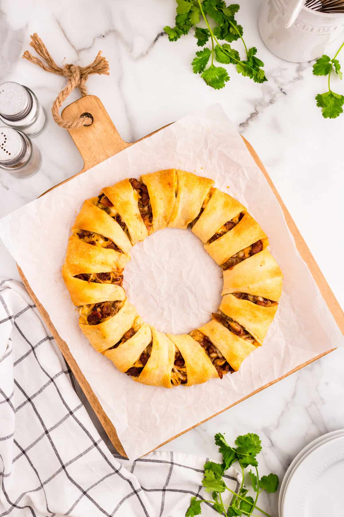 Pulled Pork Crescent Ring baked to golden brown on parchment lined cutting board 