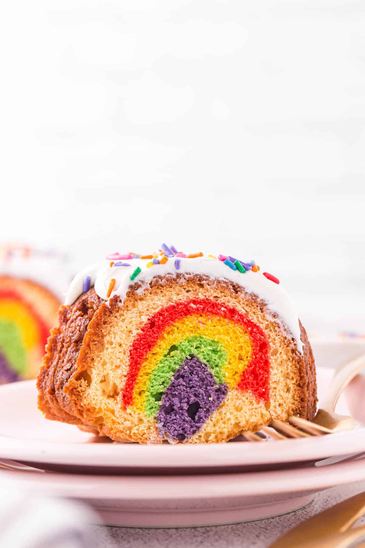 Chunk of bundt cake on a plate showing the inside of the cake with all the different colors.
