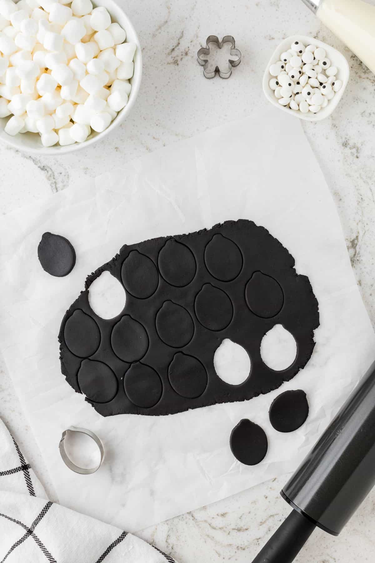 Roll out black fondant and use an oval cookie cutter to cut out the sheeps head.
