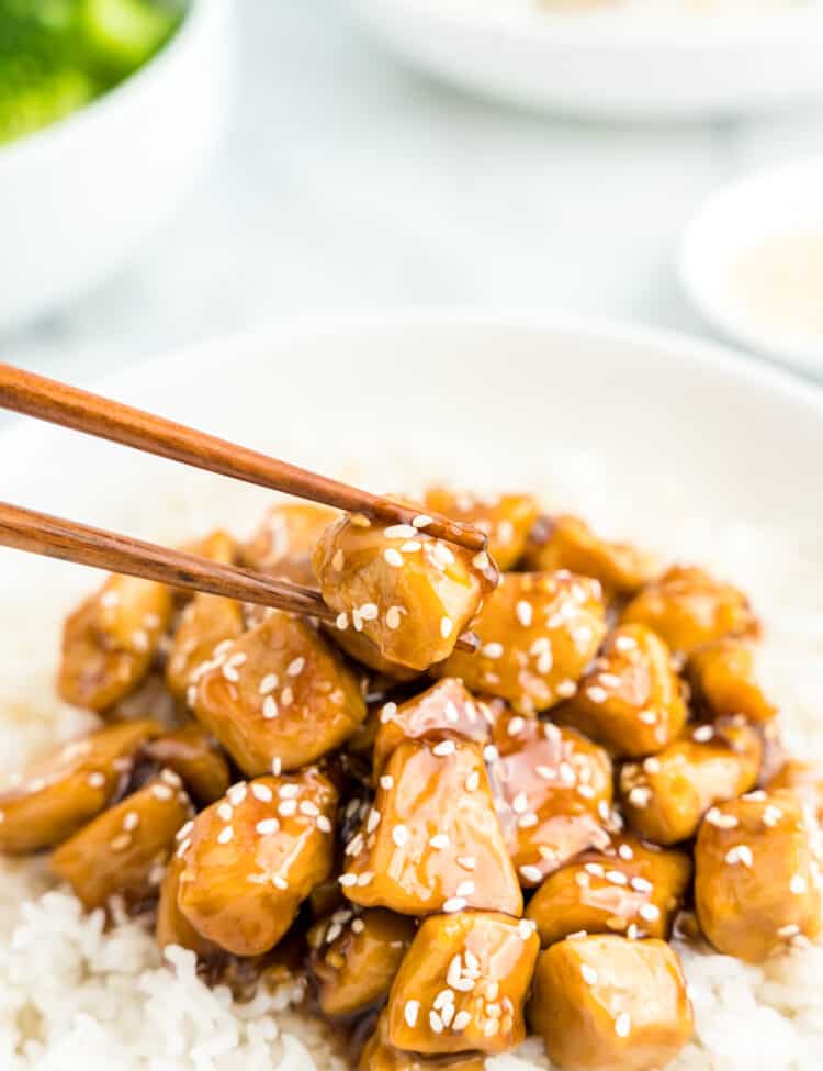 Teriyaki Chicken on top of a bed of rice in bowl with chopsticks