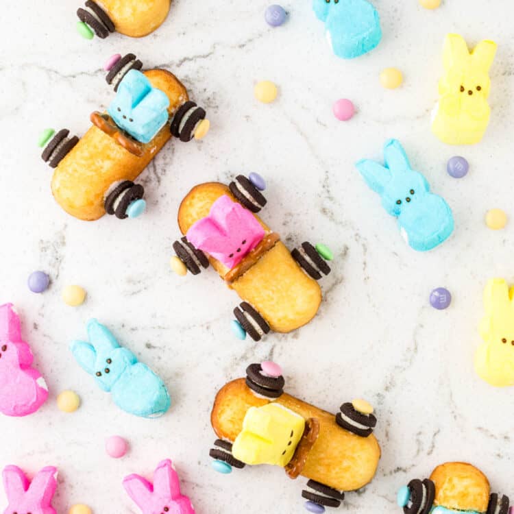 Overhead image of Multiple Twinkie bunny Cars placed on a table with peeps laying aside them.