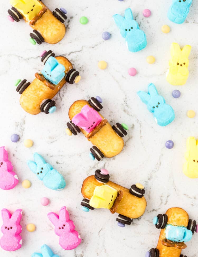 Overhead image of Multiple Twinkie bunny Cars placed on a table with peeps laying aside them.