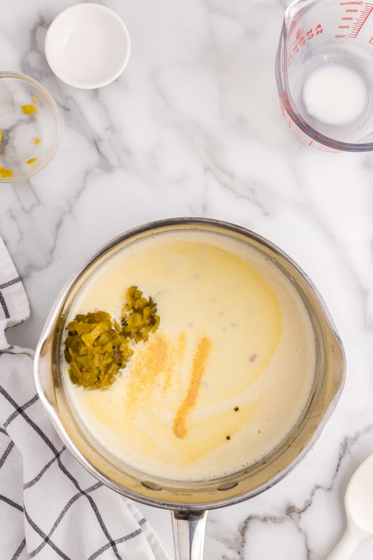 Adding green chiles and garlic powder to cheeses for White Queso Dip