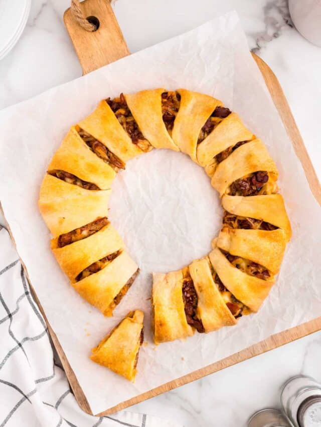 Pulled Pork Crescent Ring with one slice cut and removed on parchment paper