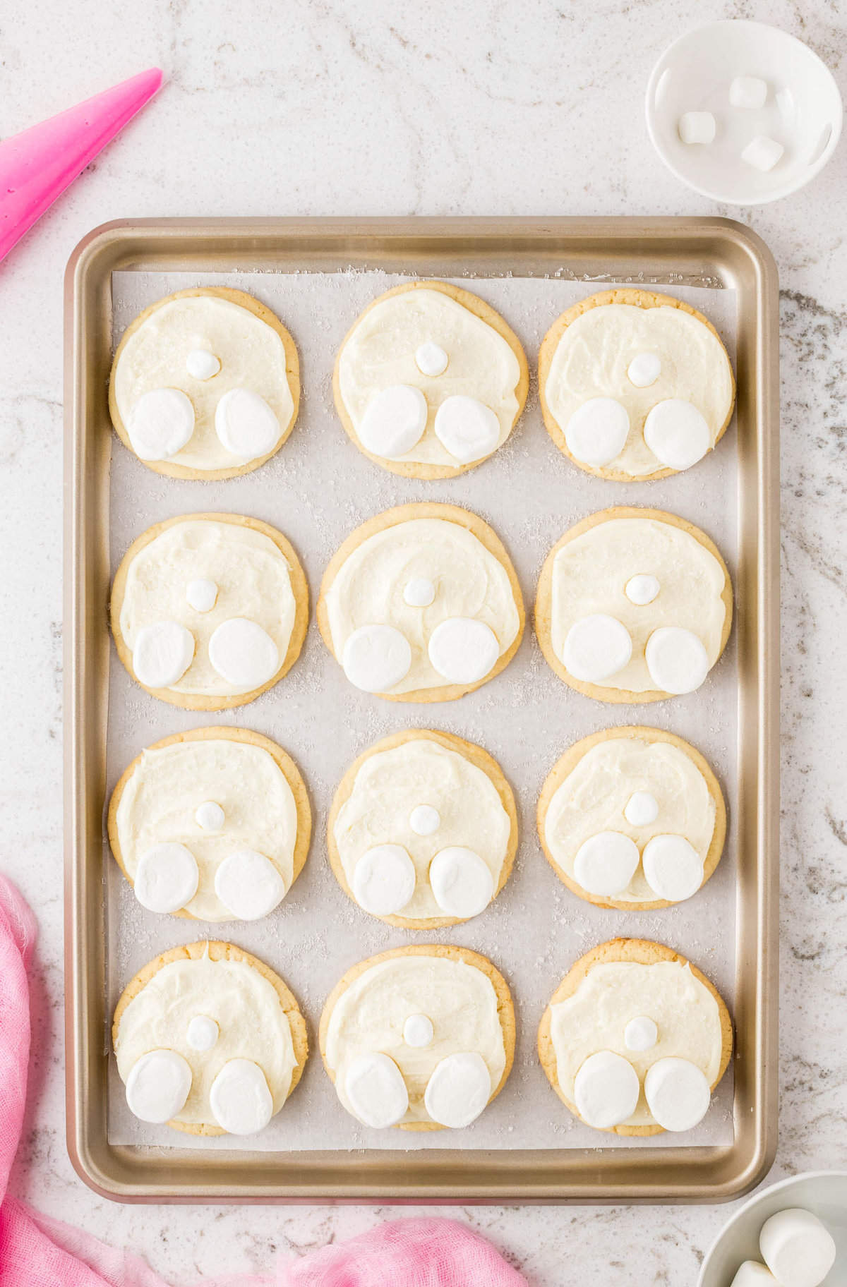 Sprinkle sugar on top of the white frosting. Then place two half marshmallows on the frosting as the bunny feet & one Mini Marshmallow in the center of the cookie for the bunny tail.