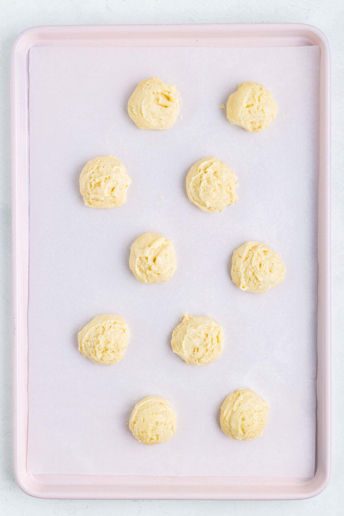 Using a medium cookie scoop drop the cookie dough onto the parchment lined cookies sheets. Bake according to package.