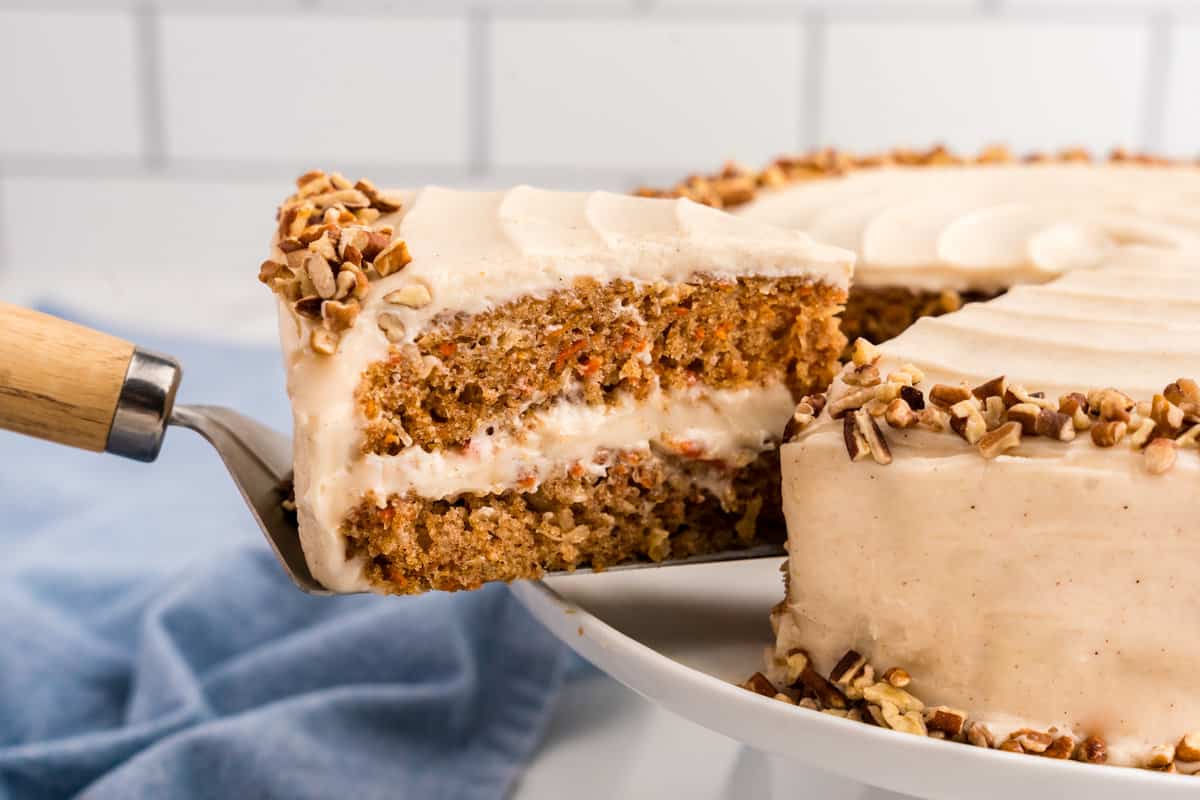 Slice of Carrot Cake being removed from cake using a spatula