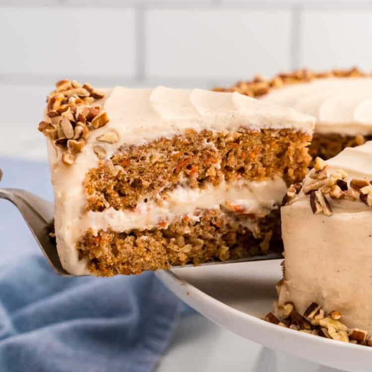 Carrot Cake slice being removed from the cake on a cake plate