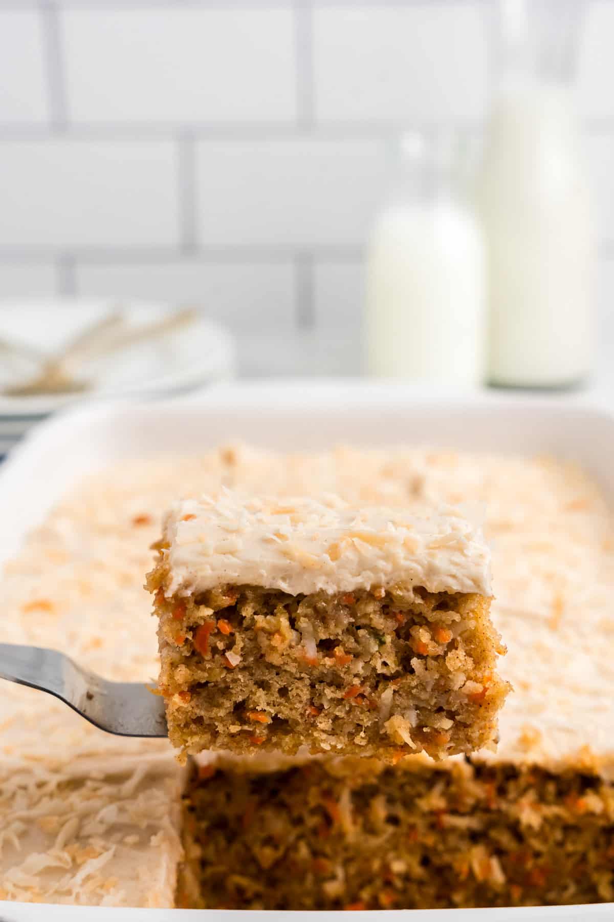 Using spatula to remove one piece of Carrot Poke Cake from baking dish