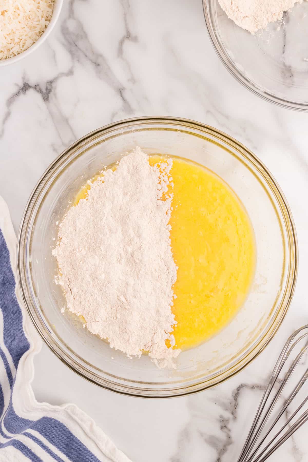 Adding in dry ingredients to the mixing bowl for Carrot Poke Cake 