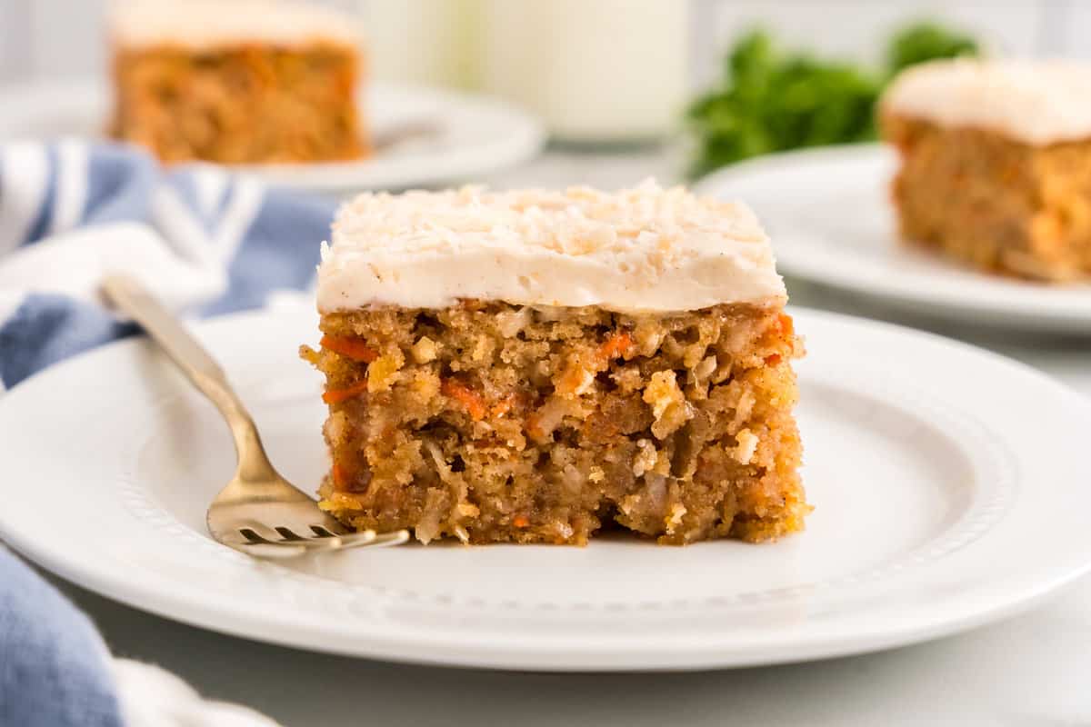 Square piece of Carrot Poke Cake on plate with fork