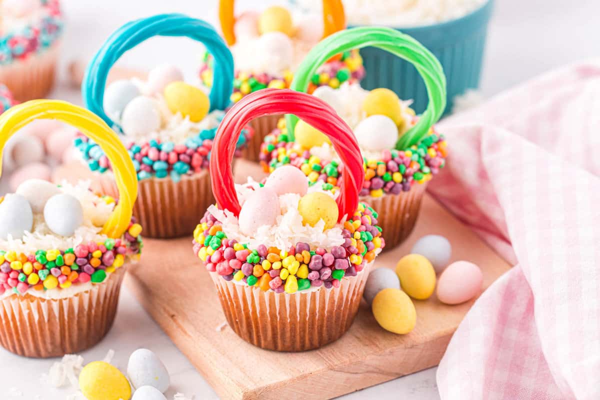 Overhead image of the cupcakes displayed on a cutting board with eggs all over the table around the cupcakes.