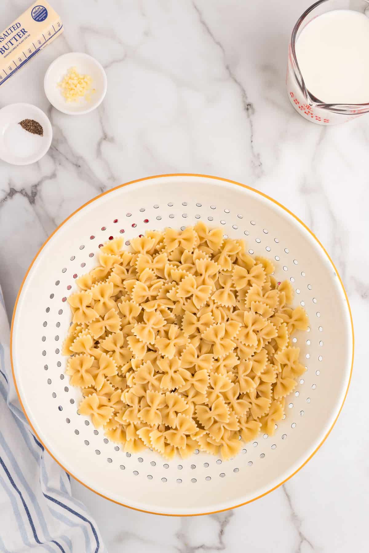 Cooked pasta in strainer for Cheesy Ham Casserole recipe