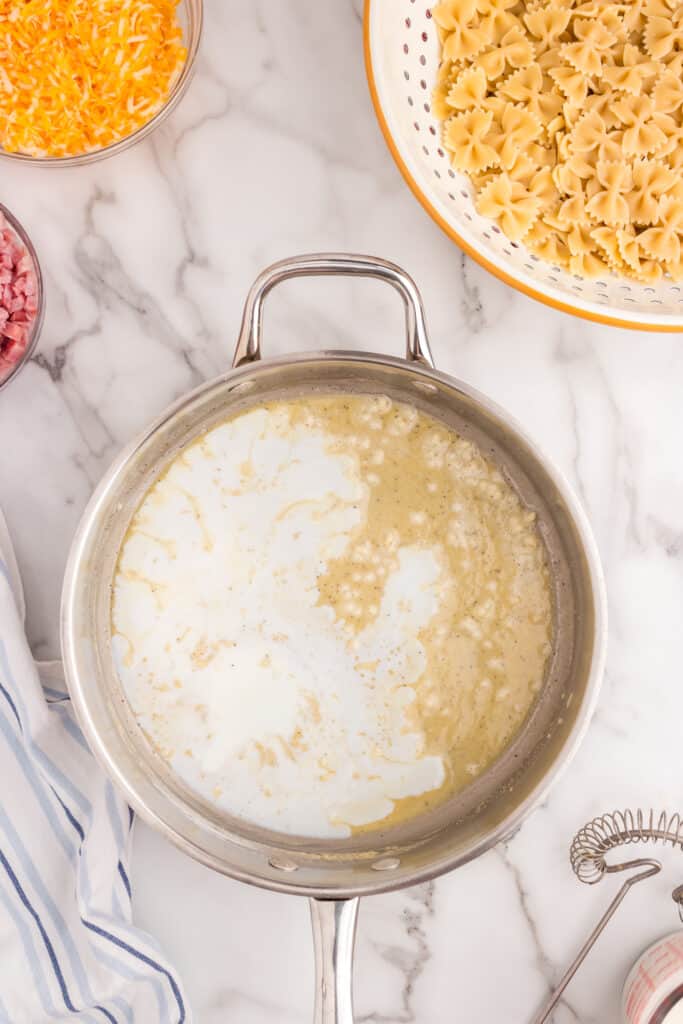 Cheese sauce ingredients in stovetop saucepan for Cheesy Ham Casserole