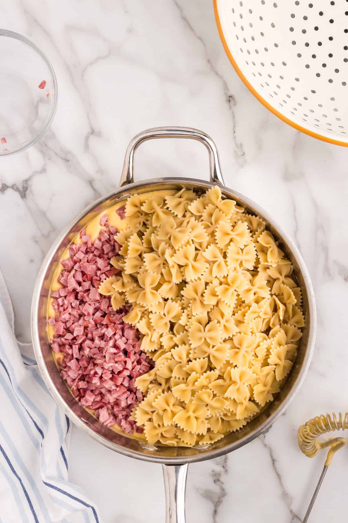 Adding in ham and cooked pasta to cheese sauce for Cheesy Ham Casserole