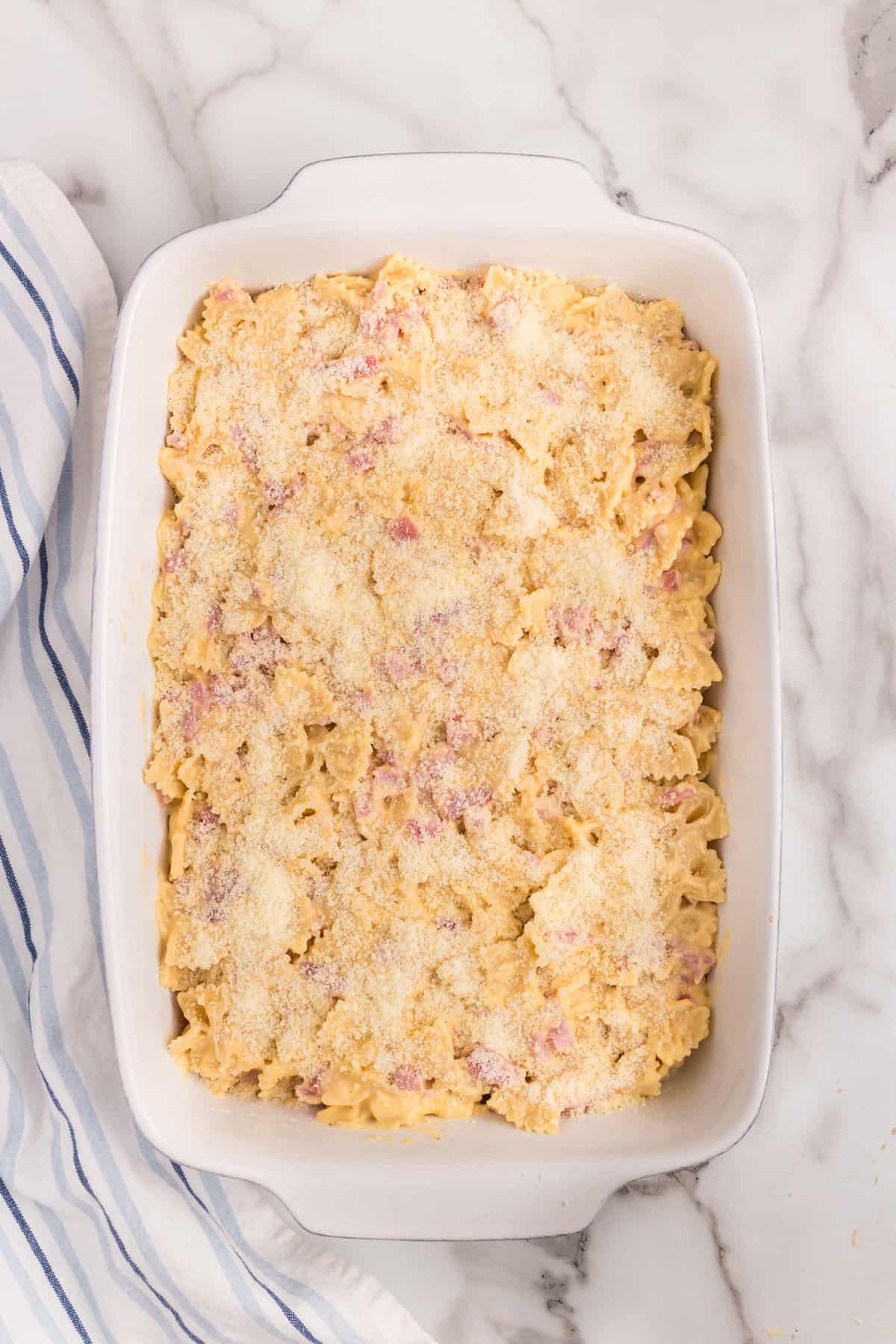 Evenly spreading Cheesy Ham Casserole ingredients in 9x13 baking dish