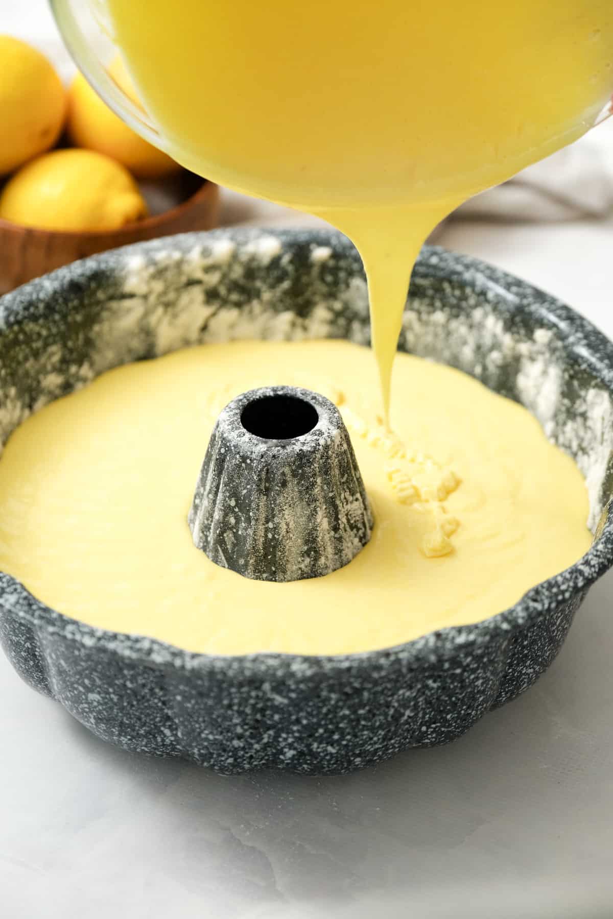 Pouring batter for Lemon Bundt Cake in floured pan