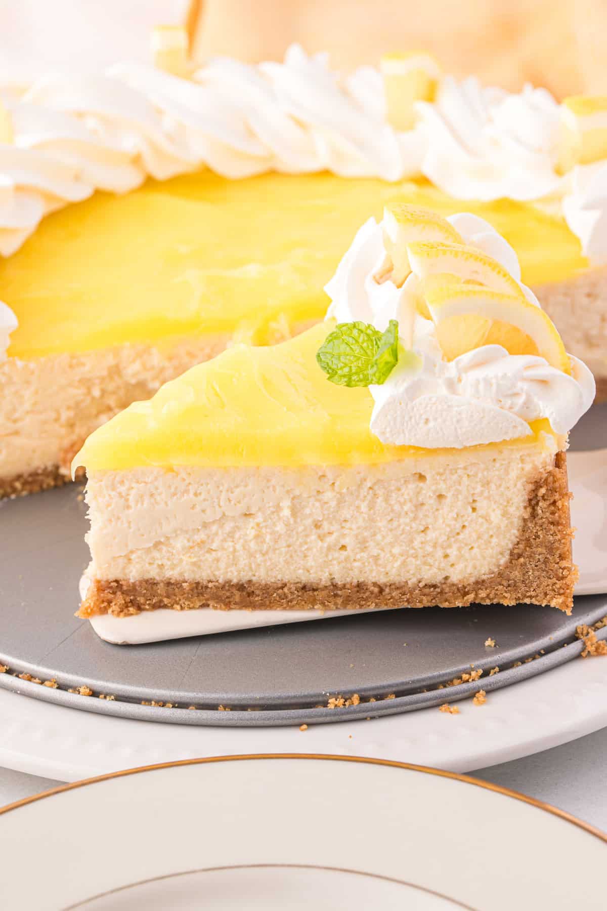 Removing one slice of Lemon Cheesecake from pan using a spatula