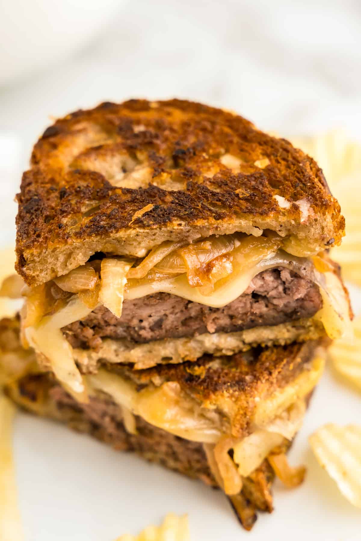 Patty Melt cut into two pieces stacked on plate