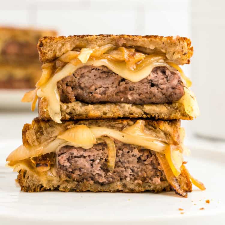 Patty Melt cut into two pieces stacked on plate