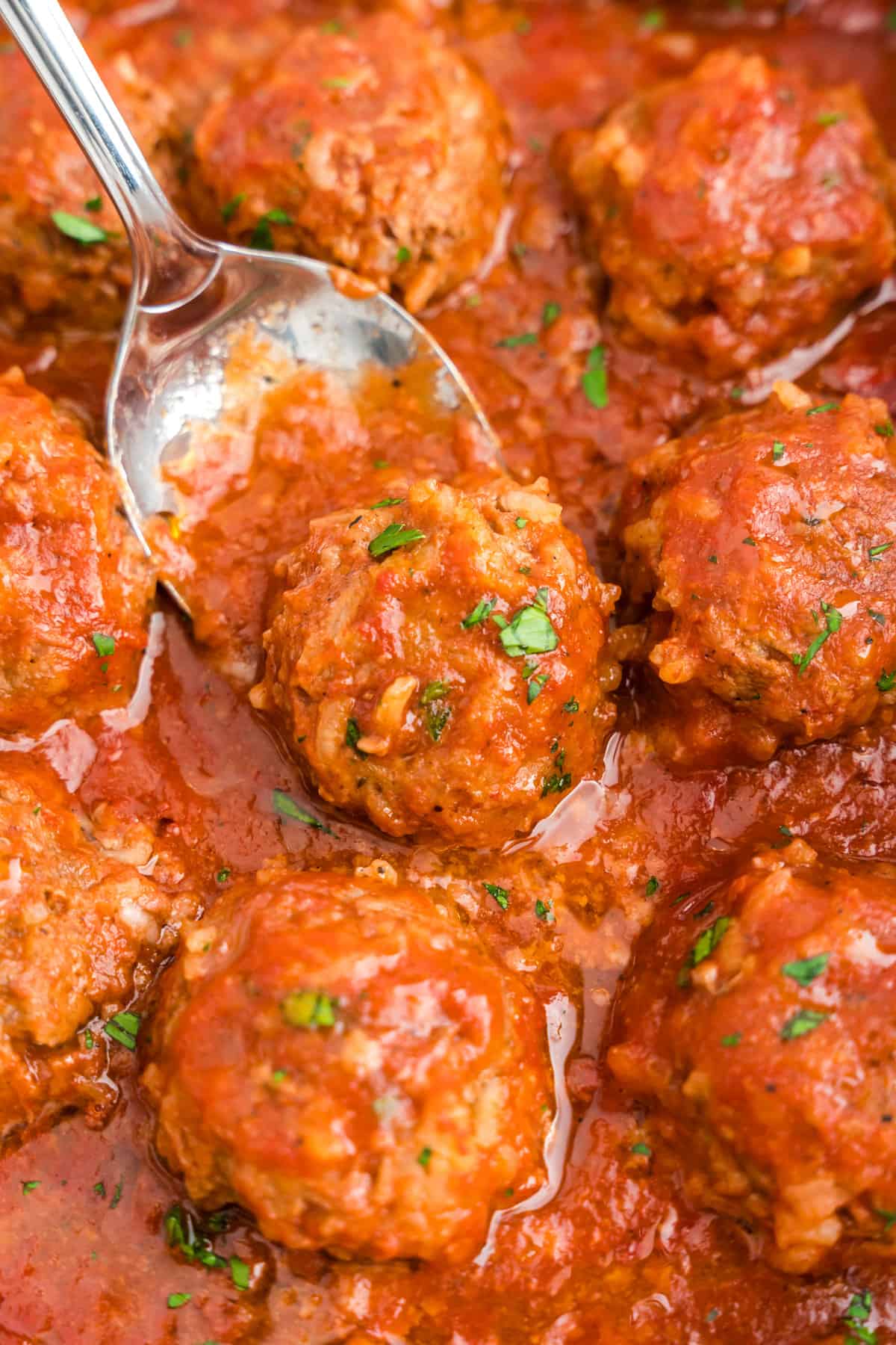 Spooning meatballs from pan