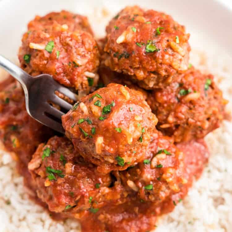 Porcupine Meatballs on a bed of rice in a serving bowl with a fork