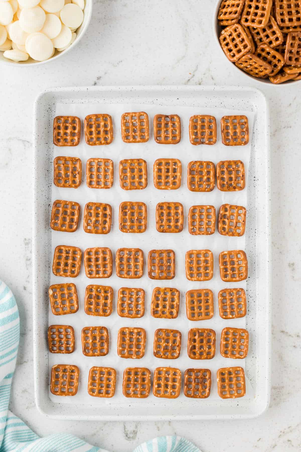 Place the square pretzels evenly separated on the prepared baking sheet.