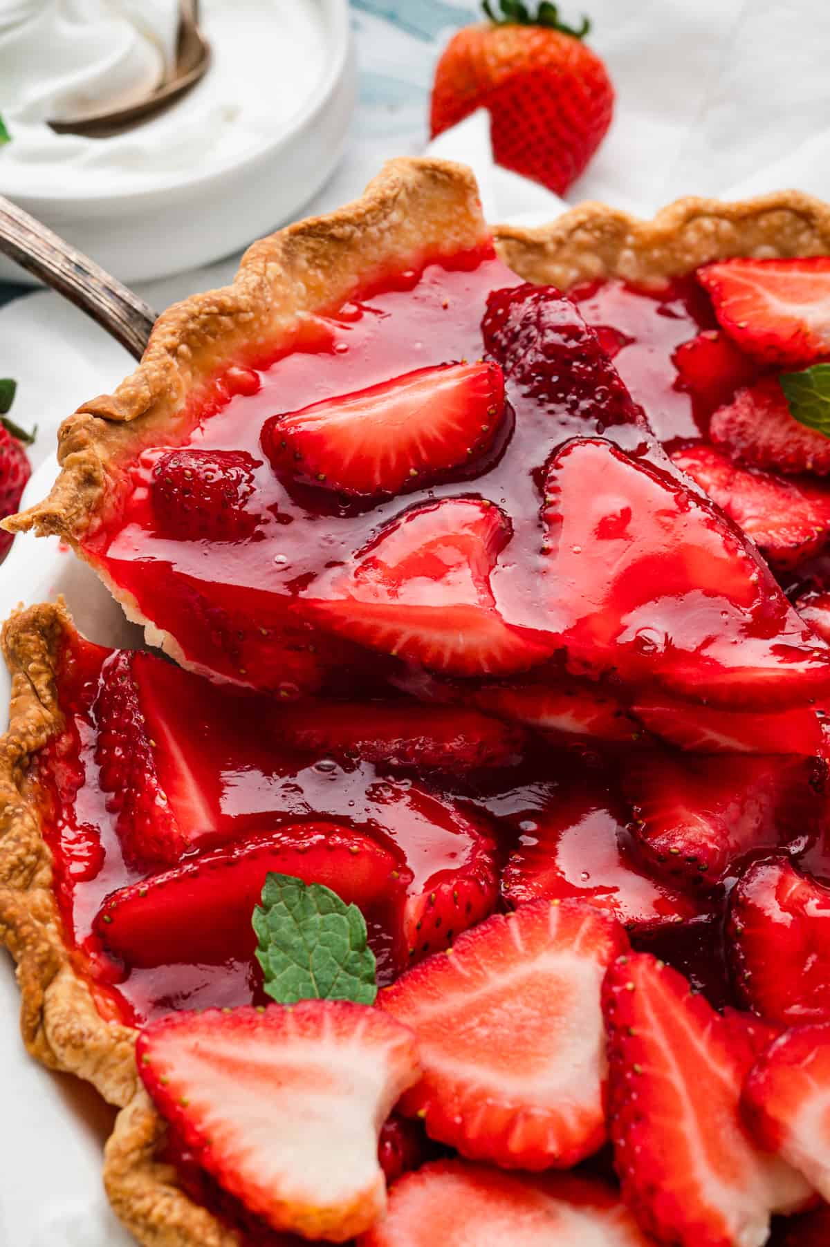 Easy Strawberry Pie cut into pieces with one being scooped out of pie pan