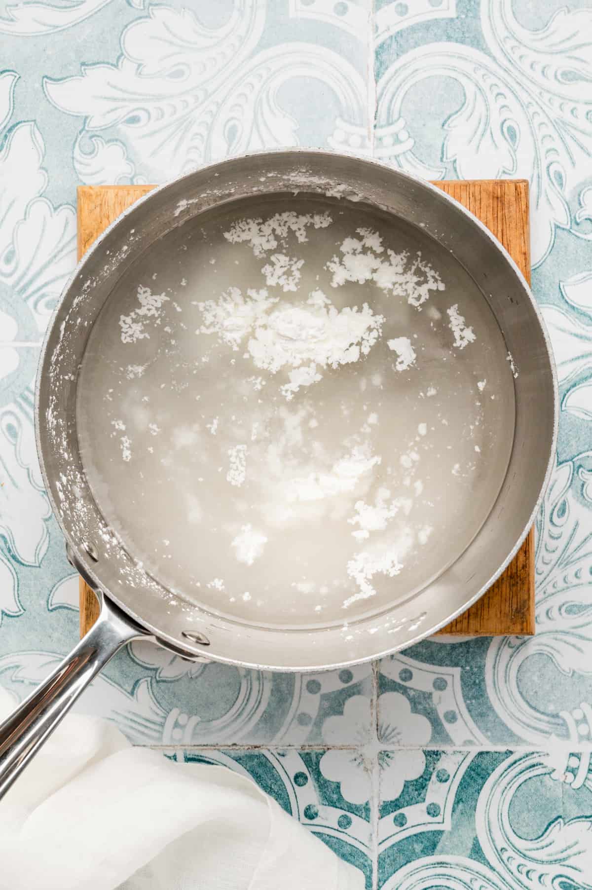 Boiling water and cornstarm in stovetop saucepan for Easy Strawberry Pie