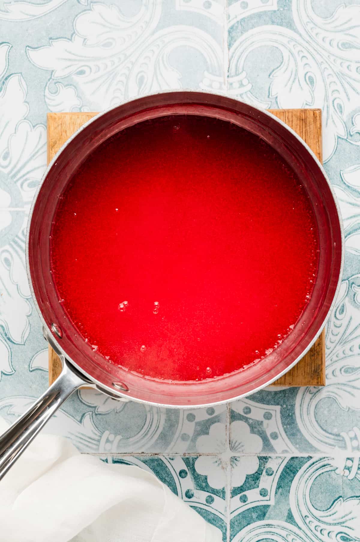 Adding strawberry Jello-O to water mixture in saucepan for Easy Strawberry Pie