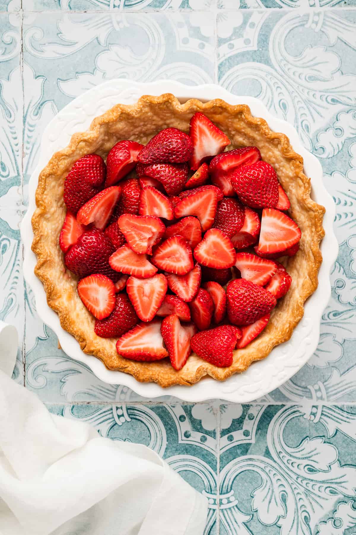 Adding prepared strawberries to crust in pie pan for Easy Strawberry Pie