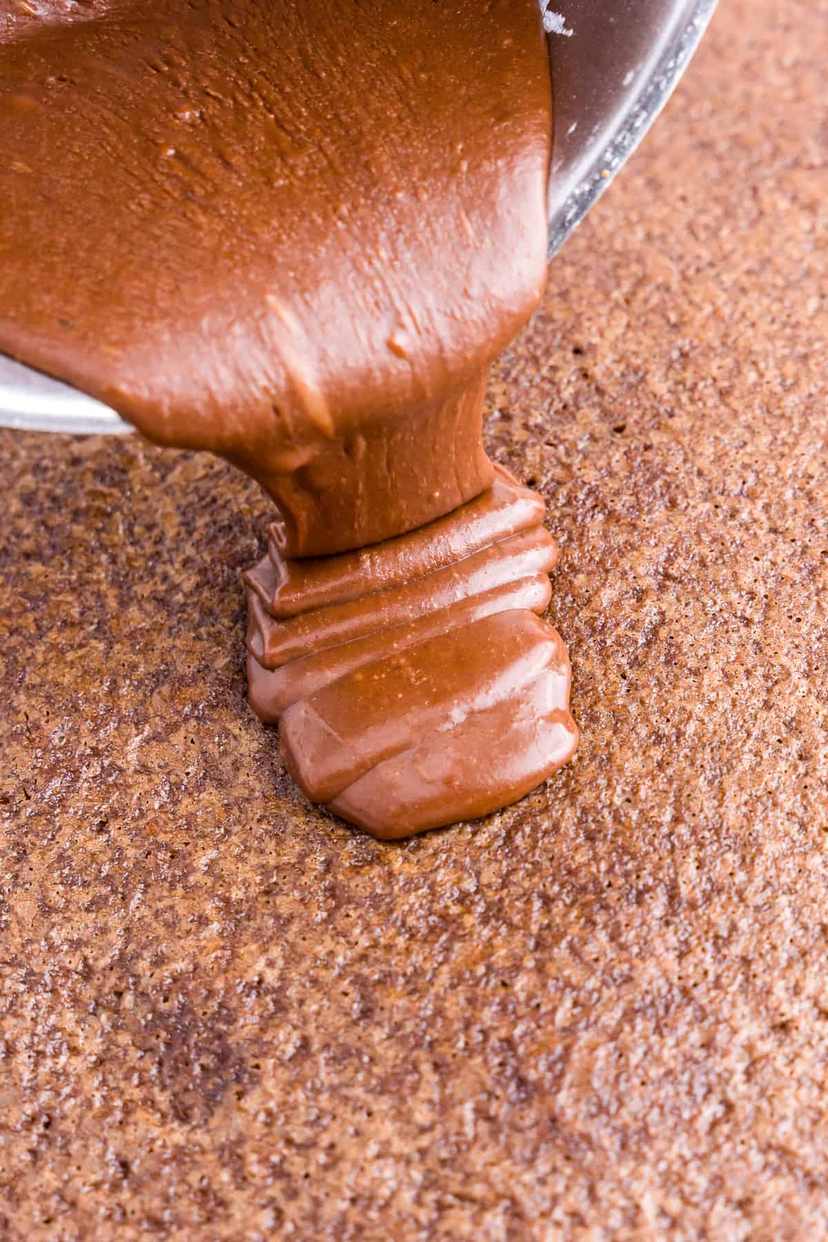 Pouring frosting over baked cake for Texas Sheet Cake recipe