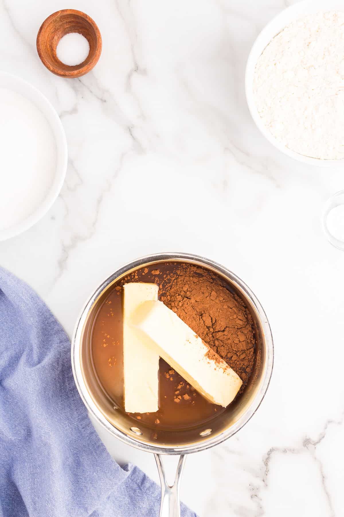 Melting butter and cocoa powder in stovetop saucepan for Texas Sheet Cake recipe