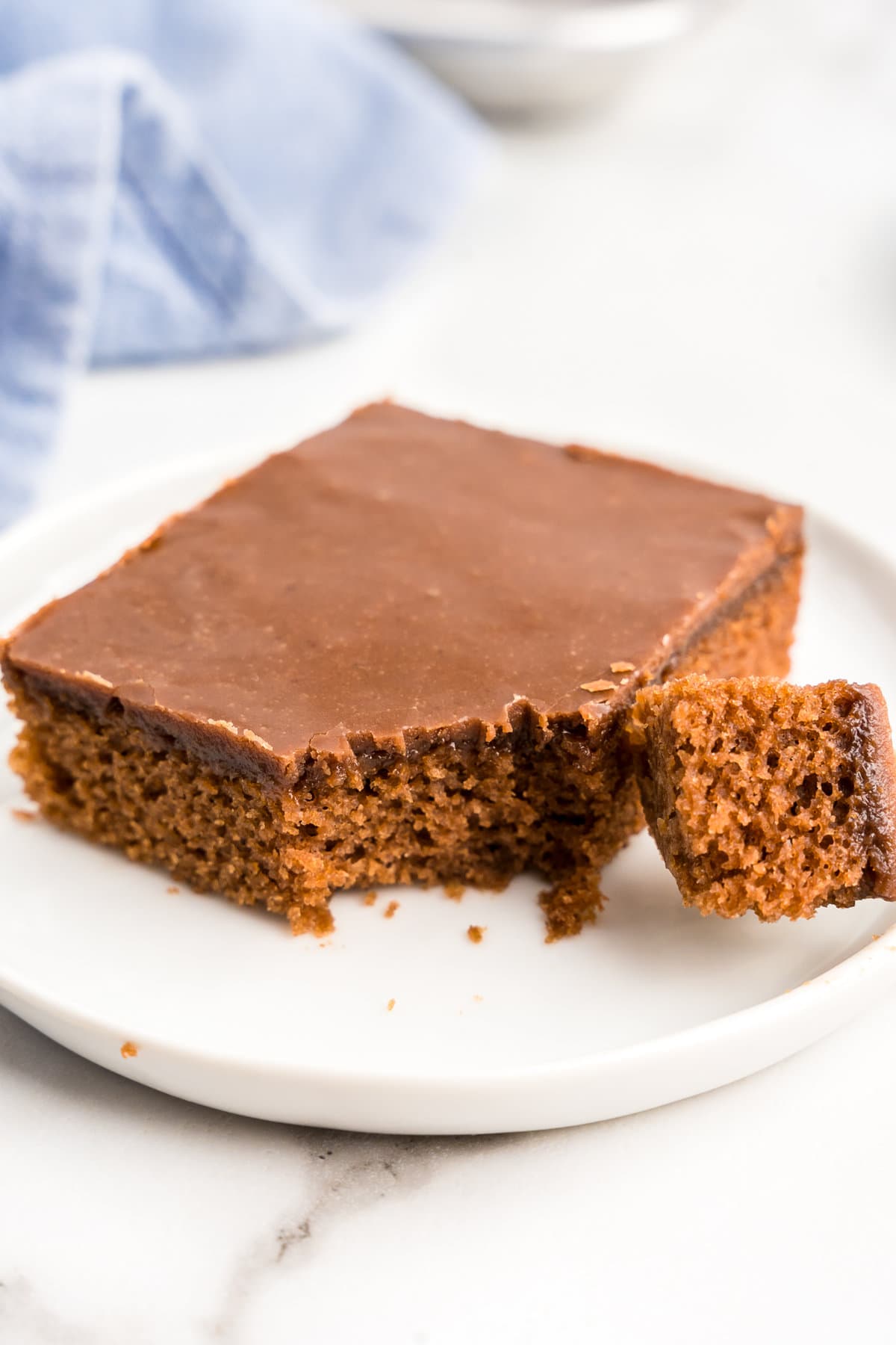 One piece of Texas Sheet Cake on plate with the first bite taken