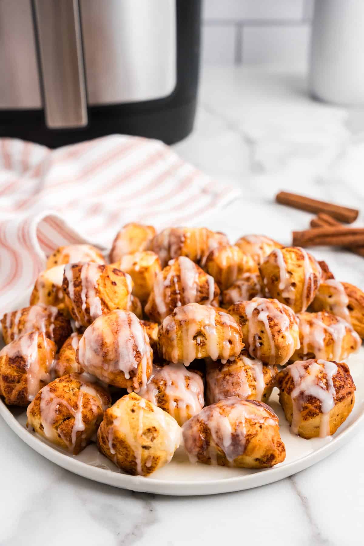 a White plate FULL of Cinnamon Roll Bites.