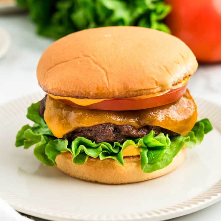 Baked Hamburger with toppings on plate ready to take the first bite