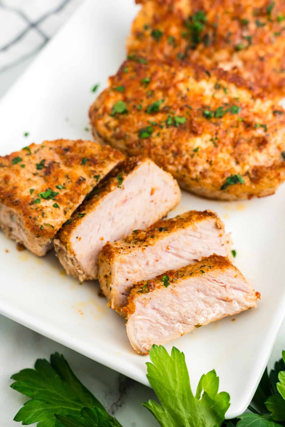 Parmesan Crusted Pork Chops sliced and arranged on serving plate