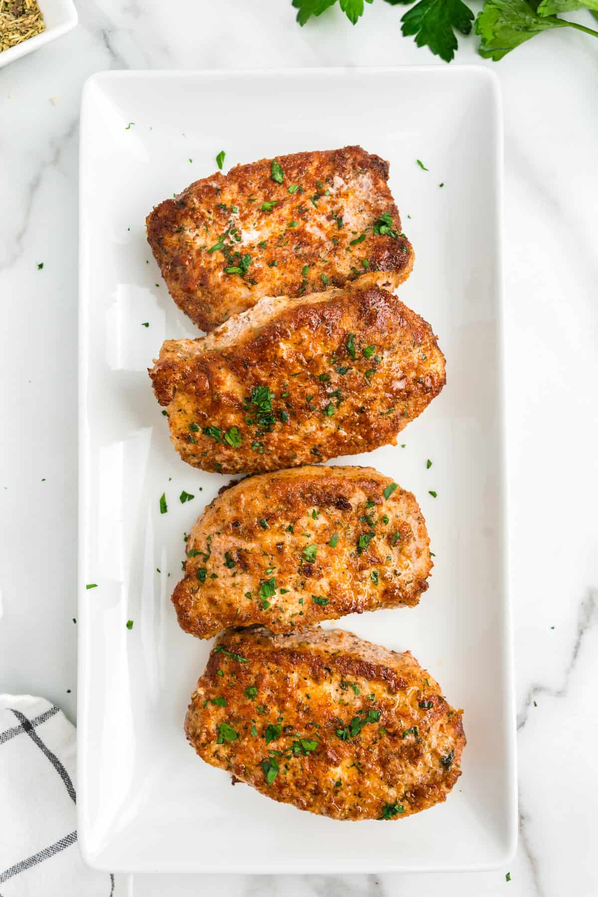 Parmesan Crusted Pork Chops lined on a serving plate