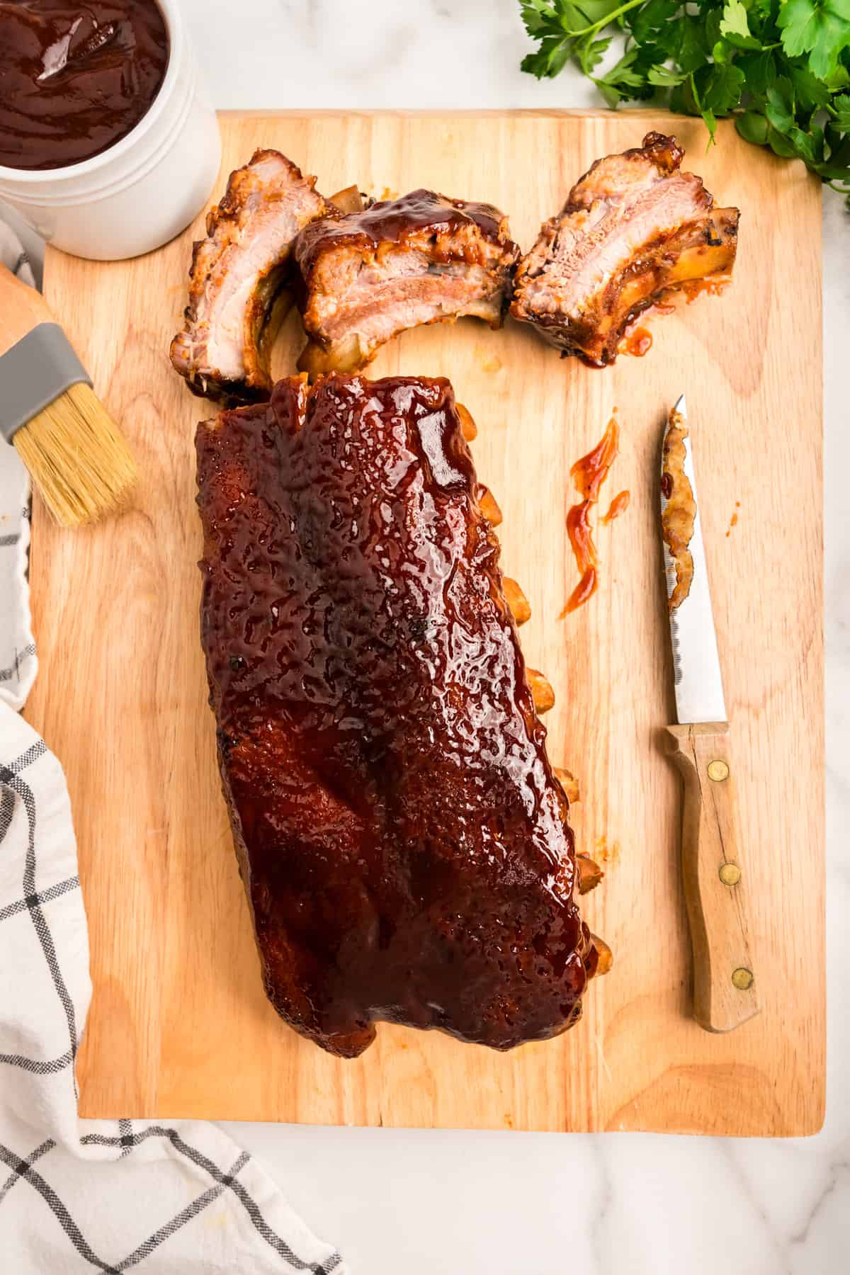 Slicing Oven Baked Ribs with knife on cutting board
