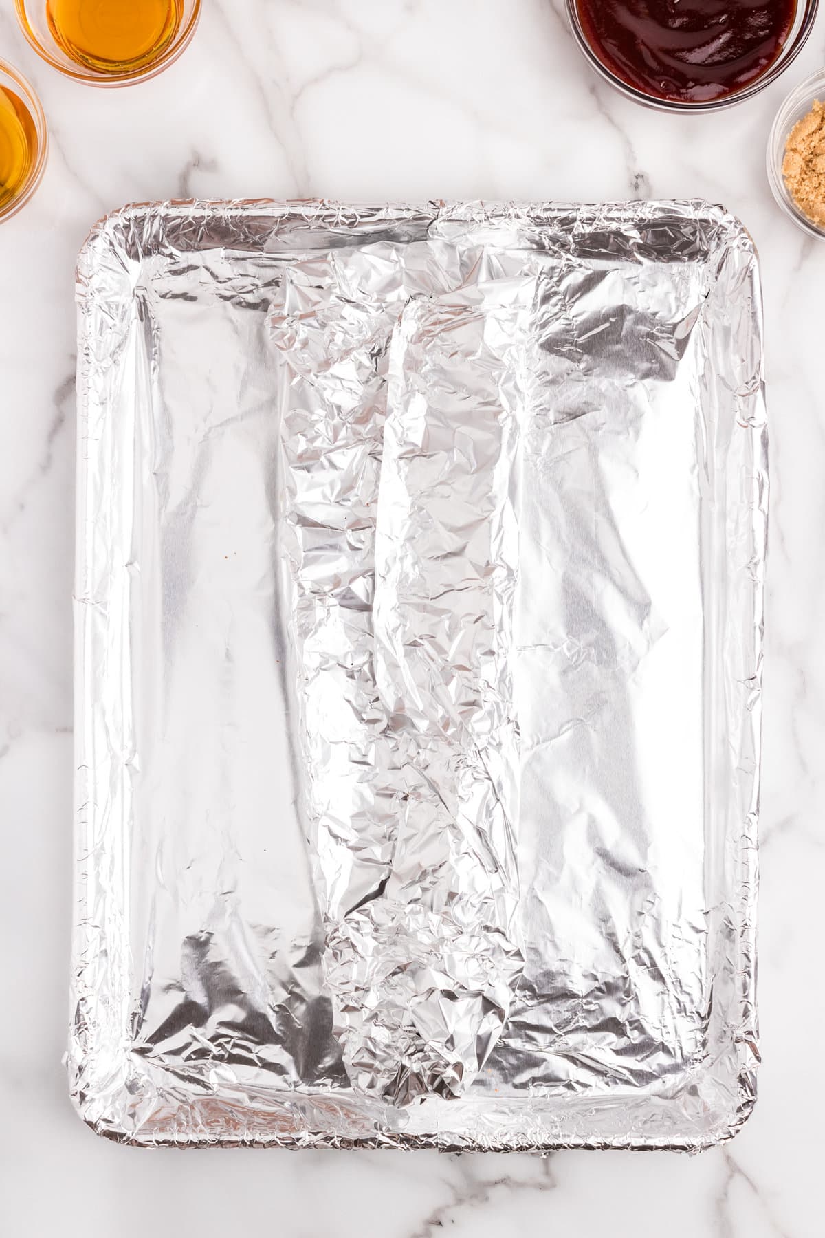 Wrapping seasoned baby back ribs in tin foil for baking the Oven Baked Ribs recipe