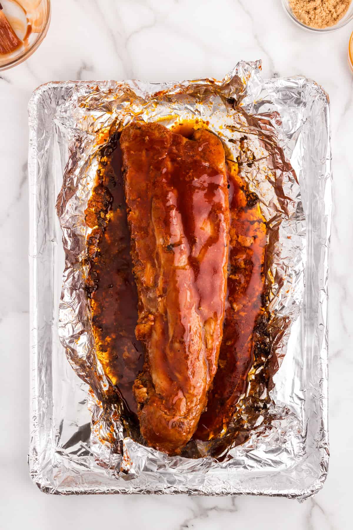 Unwrapping Oven Baked Ribs after baking to add BBQ sauce