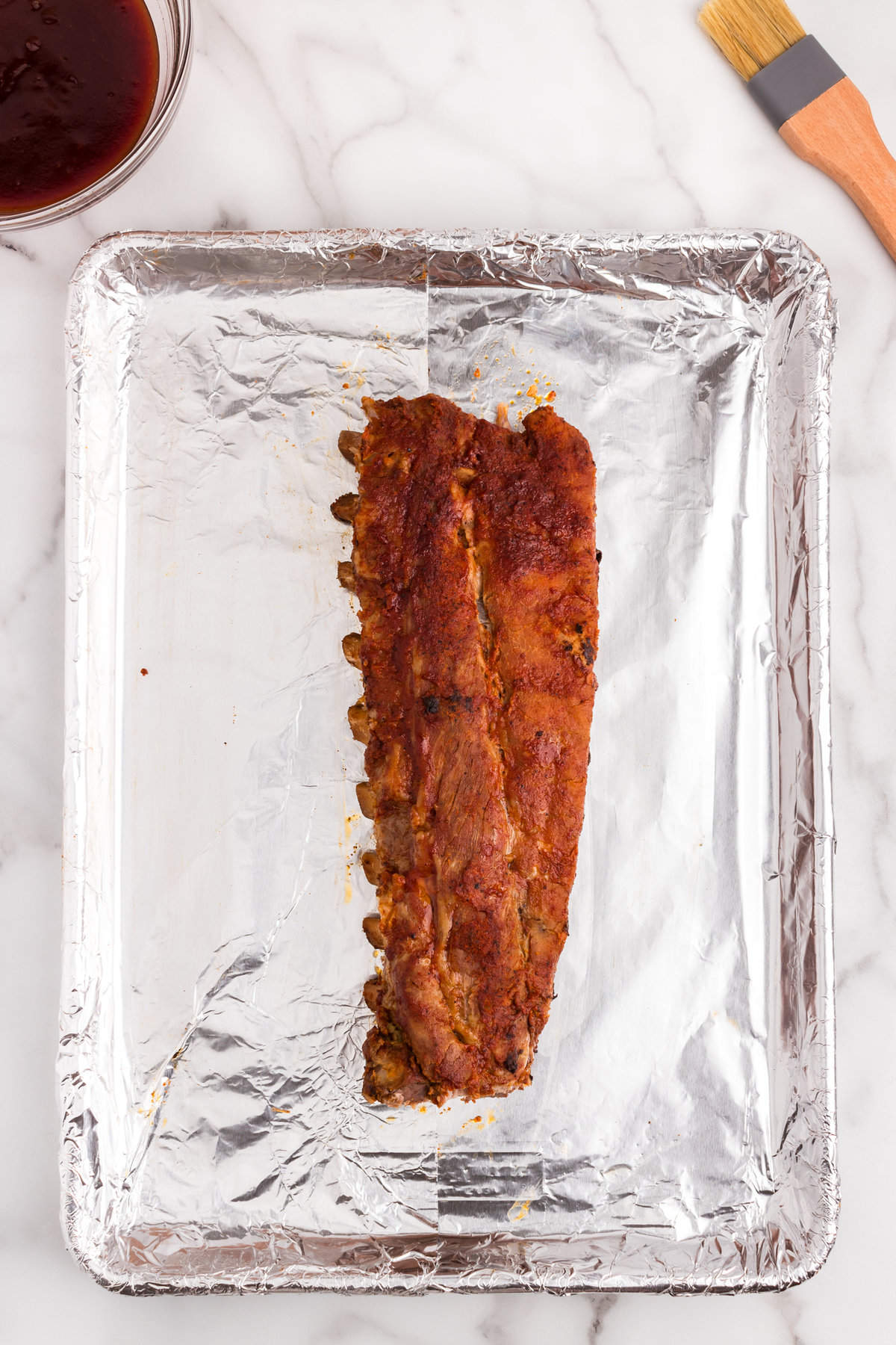 Transferring Oven Baked Ribs to tinfoil-lined baking sheet