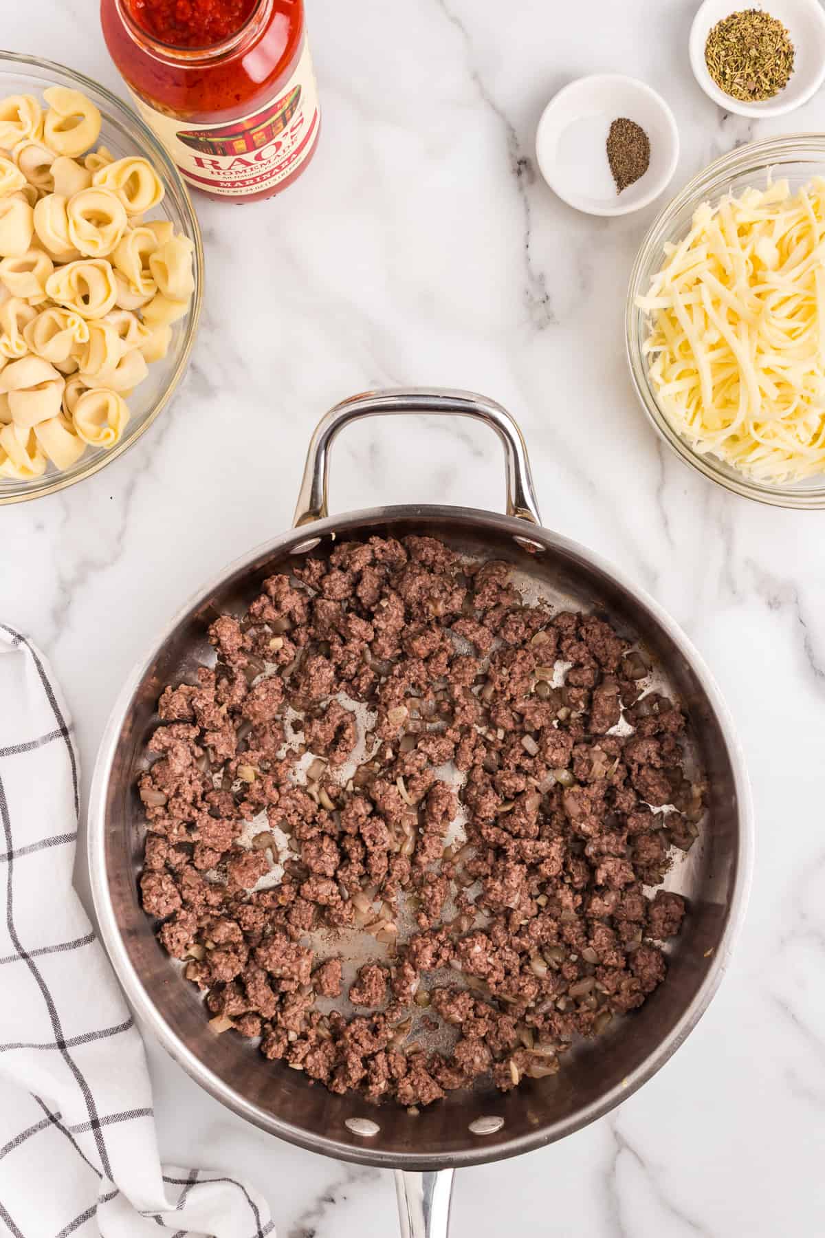 Browned and seasoned ground beef in skillet for Baked Tortellini recipe