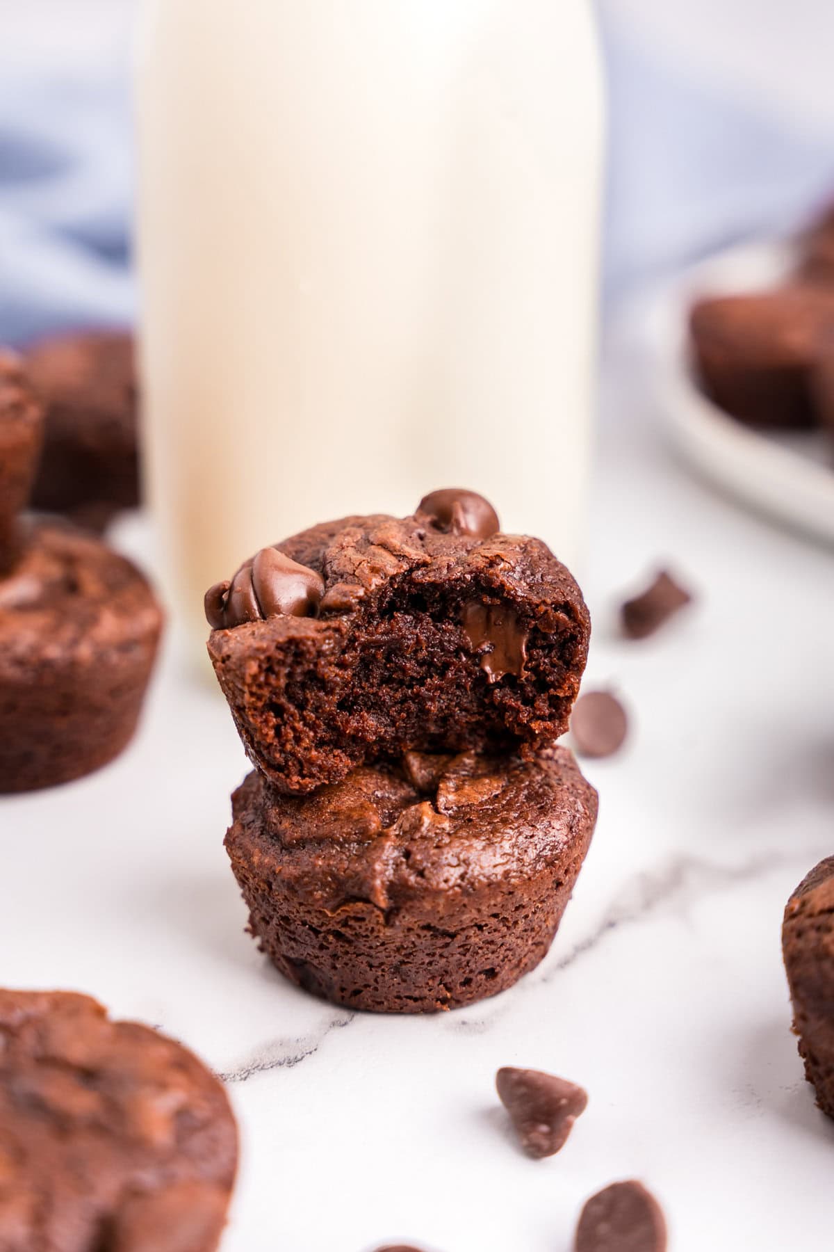 Two brownie bites stacked on top of one another with a bite taken out of the top one.