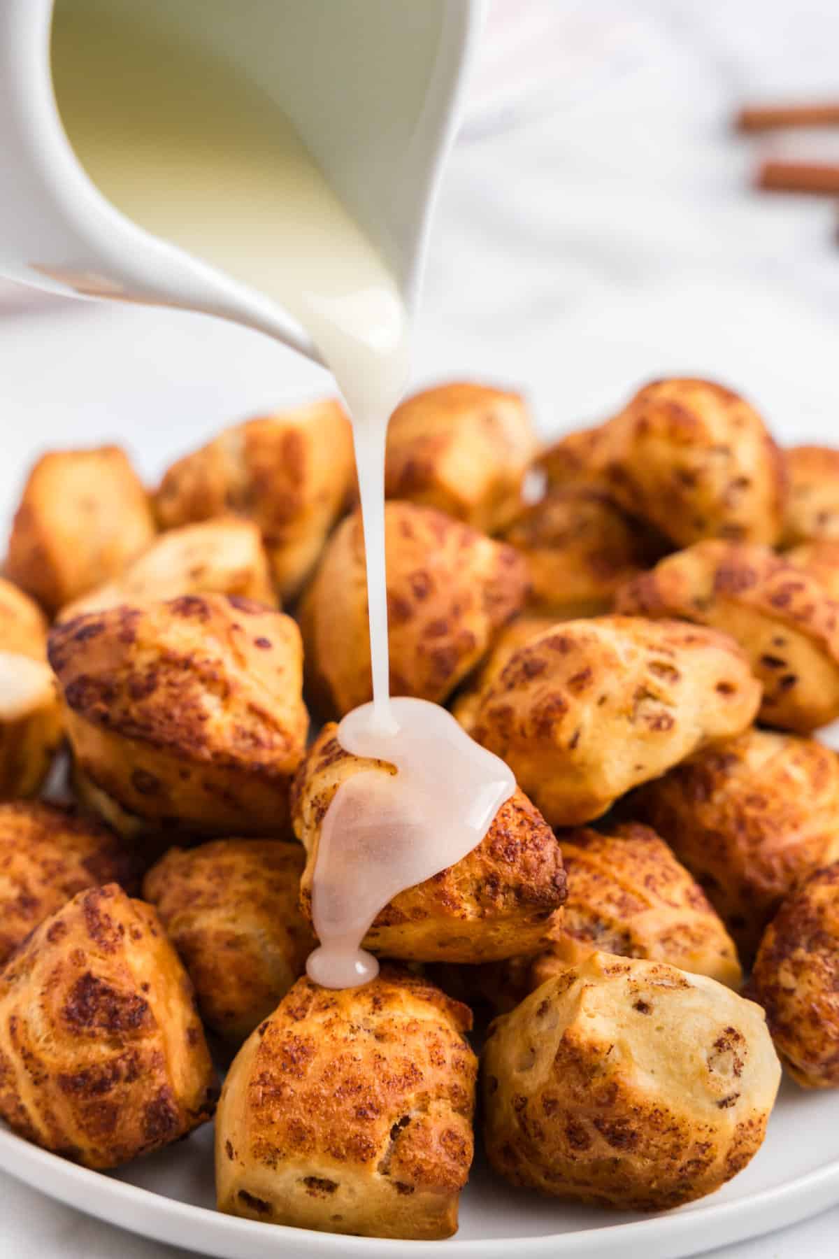 Place the bites on a plate and warm up the icing in the microwave and pour on top of the cinnamon bites.