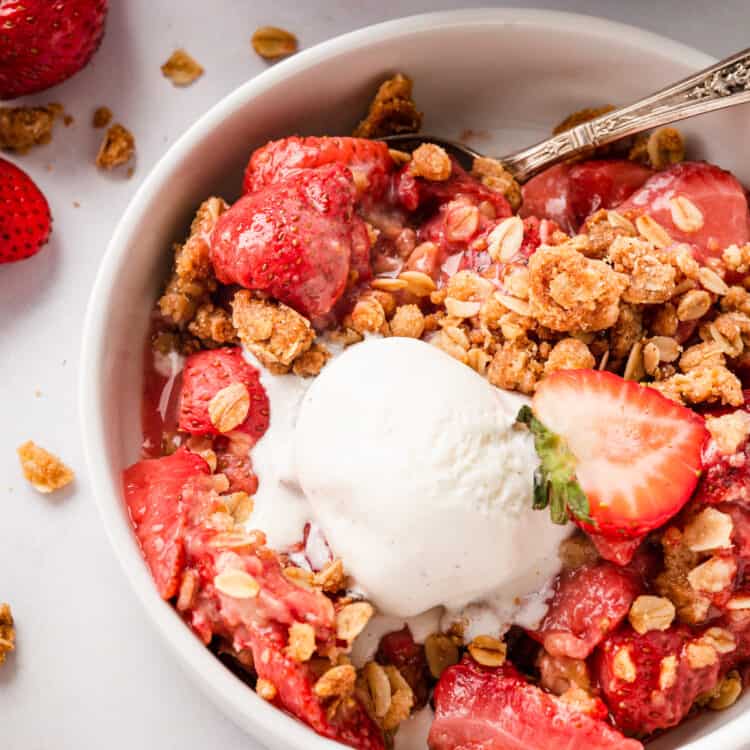 Strawberry Crisp Recipe in serving bowl topped with vanilla ice cream