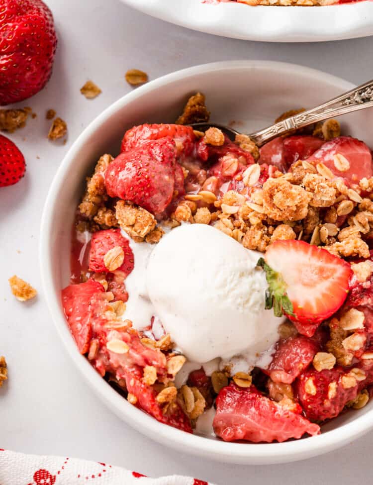 Strawberry Crisp Recipe in serving bowl topped with vanilla ice cream