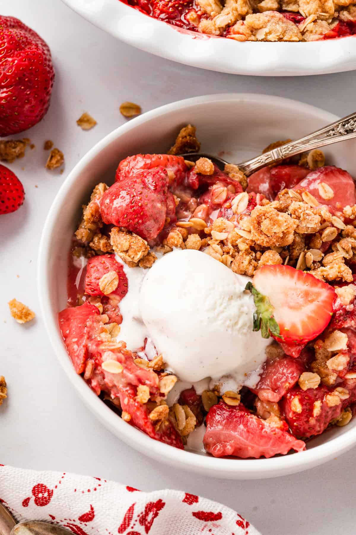 Strawberry Crisp Recipe in serving bowl topped with vanilla ice cream